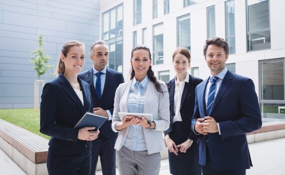 Portrait of confident businesspeople standing outside office building